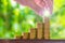 Hand put growing coins stacks with green bokeh background. Financial growth, saving money, business finance wealth and success co