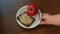 Hand puts plate with tomato and rye bread