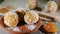 Hand puts raw vegan sweet energy balls on plate. Still life. With dried apricots, oatmeal, peanuts, coconut meat. Closeup view. Ve