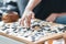 Hand putting baduk blackstone on wooden grid board