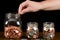 Hand putting coins into full glass jar put save money future investment saving cost financial plans currency inflation