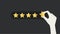 Hand putting five gold stars on black background. Five stars quality rating icon.