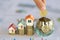 Hand putting money coin stack with small house, purchase of habitation, buy a house,Risk, Assets, Property Investment, Saving