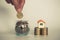 Hand putting money coin stack with small house, purchase of habitation, buy a house,Risk, Assets, Property Investment, Saving