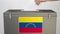 Hand putting paper ballot into ballot box with flag of Venezuela. Election related 3d rendering