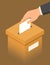 Hand putting paper in the brown ballot box