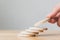 Hand putting wooden coins stacking as step stair on top