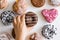 Hand reaches for a donut with chocolate. Donuts with colored icing on a white background