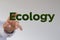 Hand reaching for the illustrated word "Ecology"