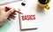 Hand with red pen. Cofee cup. Stick. Keyboard and white background. BASICS sign in the notepad