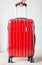 Hand on red travelling suitcase