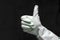 A hand reflection in a mint green rubber glove shows thumbs up in a dark room