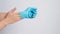 Hand is remove blue latex gloves by putting the fingers inside the glove on white background