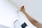 Hand of repairman painting wall with paintbrush