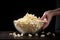 hand revealing a bowl of freshly popped popcorn