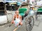 A hand rickshaw puller waits for passengers