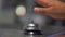 Hand ringing silver counter bell with blurry background