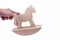 Hand rocking a simple wooden rocking horse toy gesture, figure on a stand. Propelling, moving or putting something in motion