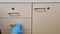 Hand in rubber glove opens a drawer in office cabinet