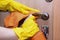 A hand in a rubber glove rubs the door handle. Disinfection at home during the epidemic