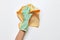 A hand in a rubber glove washes with a rag on a white background, professional cleaning and housekeeper service