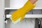 Hand in rubber protective glove with microfiber rag is cleaning a cupboard in room. Household chores. Ð¡leaning or regular clean