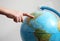 Hand\'s child pointing on a globe