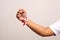 Hand\'s man holding indonesian flag with red whit ribbon on the wrist. Isolated on gray background