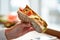 Hand with salmon panini sandwich at restaurant