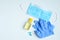 Hand sanitizer gel bottle, face mask, rubber gloves, pills on blue background. Coronavirus Disease Covid-19 prevention and