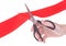 Hand with scissors cutting red ribbon