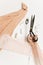 Hand of seamstress on the background of fabrics and scissors on the table. Scissors, fabric, a seam Ripper, centimeter and thread