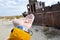 Hand with seashells on a background of ship in the desert