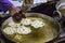 Hand seen pouring pastry into hot oil