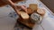 Hand selecting a cheese from a table with a variety of cheeses, on a traditional tile countertop