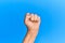 Hand of senior hispanic man over blue isolated background doing protest and revolution gesture, fist expressing force and power