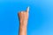 Hand of senior hispanic man over blue isolated background showing little finger as pinky promise commitment, number one