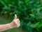 Hand of a senior woman showing success gesture with nature background. Space for text. Concept of aged people and body part