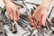 Hand of serviceman repairing parts of the mechanism in workshop