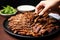 hand serving grilled bulgogi strips on a plate