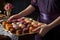 hand serving a tray of assorted donuts