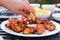 hand setting down grilled lobster tails on a plate