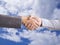 Hand shake in front of blue sky, business dual with new goal and success concept