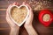 hand-shaped heart hovering above bowl of muesli