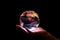 Hand showcasing holographic globe in a dark backdrop