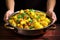 hand showcasing a well-cooked dish of aloo gobi