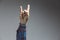 hand showing rock on or bulls horns gesture in studio shot isolated on grey background