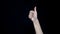 Hand sign meaning like. Close-up of thumb sign up. Good hand gesture. Black isolated background