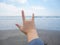 Hand signage of rock. rock symbol finger on the sea beach.