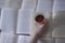 A hand with a silver bracelet holding a cup of tea with a double bottom on books pages